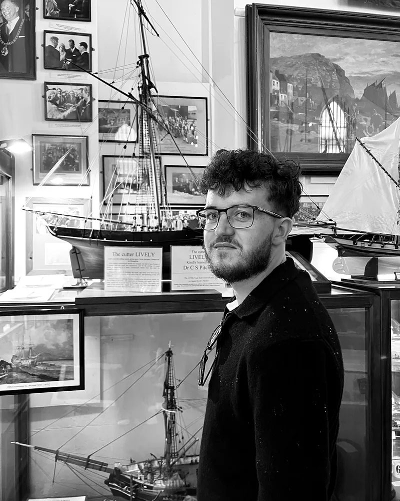 Black and white portrait of William John in a maritime museum